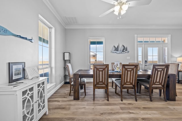 dining space featuring light wood-type flooring, ceiling fan, and crown molding