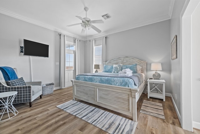 bedroom with ceiling fan, wood-type flooring, and ornamental molding