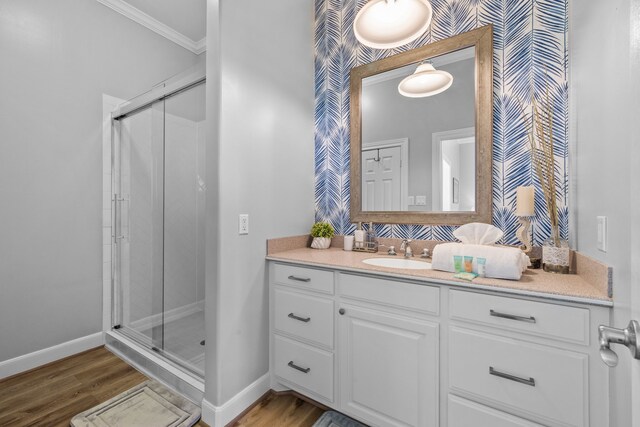 bathroom featuring crown molding, vanity, wood-type flooring, and walk in shower