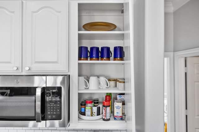 details featuring white cabinetry and ornamental molding