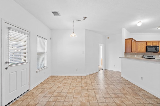 kitchen with electric range, tasteful backsplash, and hanging light fixtures