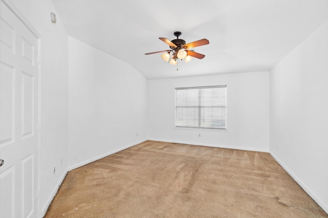 carpeted spare room featuring ceiling fan and lofted ceiling