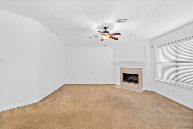 unfurnished living room featuring a fireplace, light colored carpet, vaulted ceiling, and ceiling fan