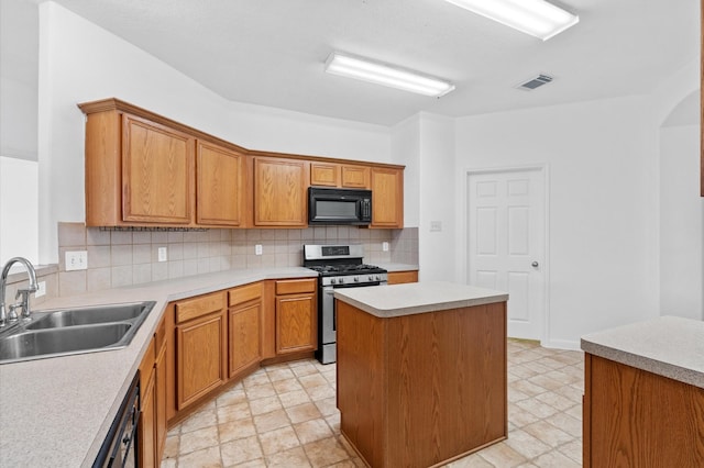 kitchen featuring sink, a center island, tasteful backsplash, and stainless steel gas range