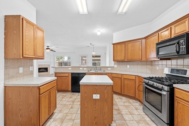 kitchen with a center island, black appliances, sink, tasteful backsplash, and kitchen peninsula