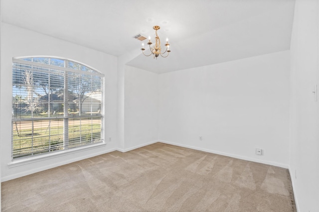 carpeted empty room featuring a notable chandelier