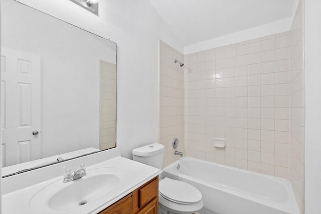 full bathroom with vanity, tiled shower / bath combo, toilet, and lofted ceiling