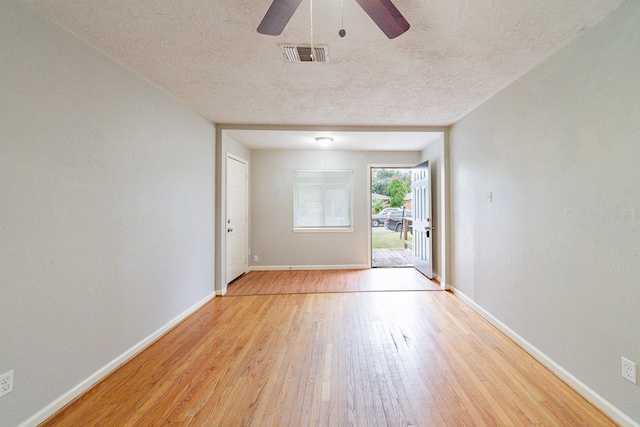 interior space with ceiling fan, a textured ceiling, and light hardwood / wood-style flooring