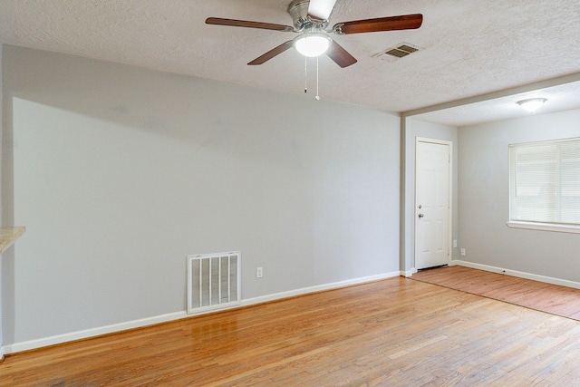 unfurnished room featuring a textured ceiling and light hardwood / wood-style flooring