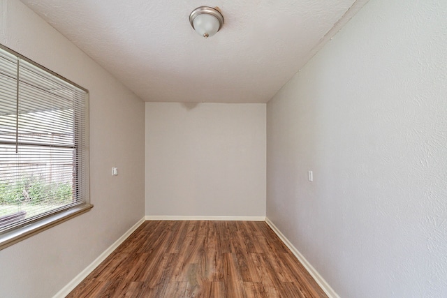 unfurnished room with dark wood-type flooring