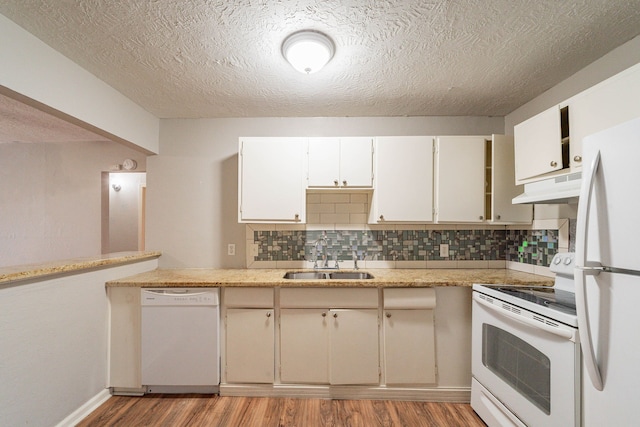 kitchen with decorative backsplash, sink, white appliances, and light wood-type flooring