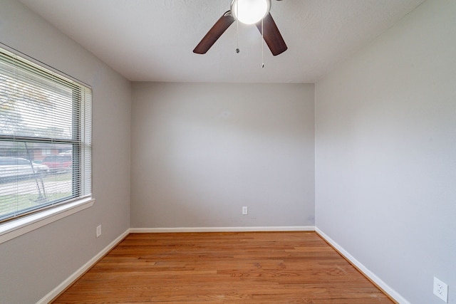 spare room with a textured ceiling, light hardwood / wood-style flooring, ceiling fan, and a healthy amount of sunlight