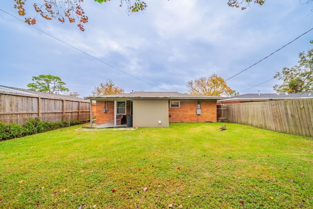 rear view of house featuring a patio area and a yard