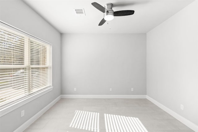 tiled spare room featuring ceiling fan