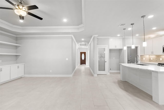 kitchen with pendant lighting, backsplash, ceiling fan, light stone countertops, and white cabinetry