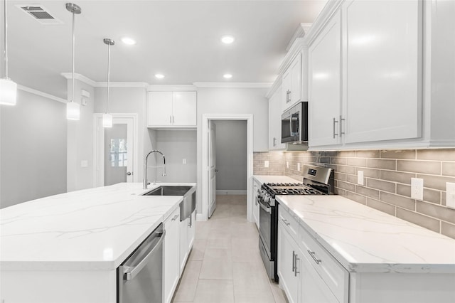 kitchen with hanging light fixtures, an island with sink, light stone counters, white cabinetry, and stainless steel appliances