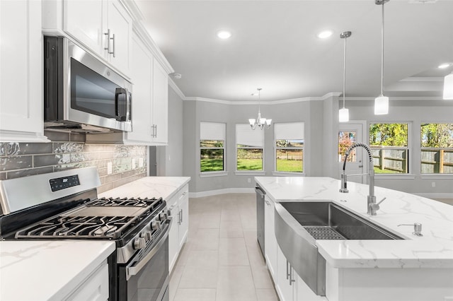 kitchen with a kitchen island with sink, white cabinets, hanging light fixtures, and appliances with stainless steel finishes