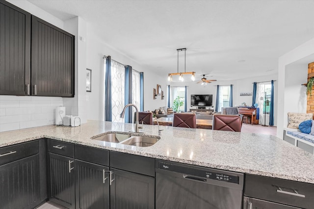 kitchen featuring ceiling fan, sink, light stone counters, stainless steel dishwasher, and pendant lighting