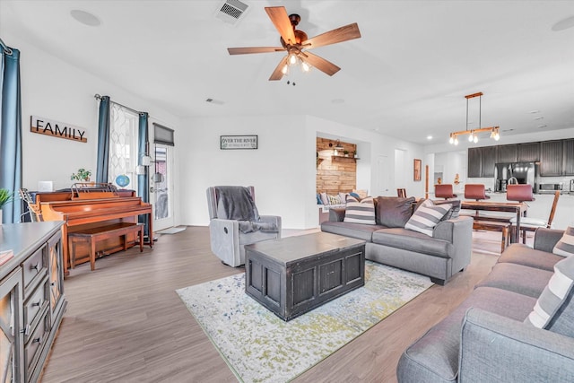 living room with light wood-type flooring and ceiling fan