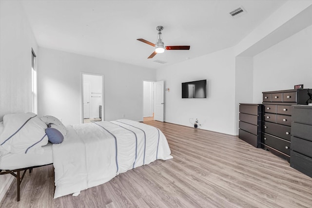 bedroom featuring ceiling fan, connected bathroom, and light hardwood / wood-style flooring