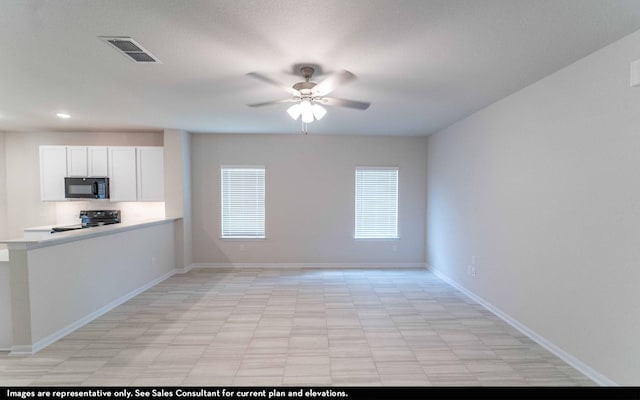 interior space featuring white cabinets, ceiling fan, and black appliances