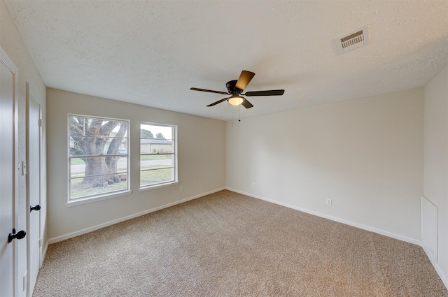 carpeted spare room featuring a textured ceiling and ceiling fan