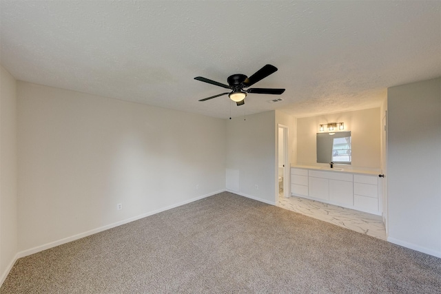 unfurnished living room featuring ceiling fan, light colored carpet, and a textured ceiling