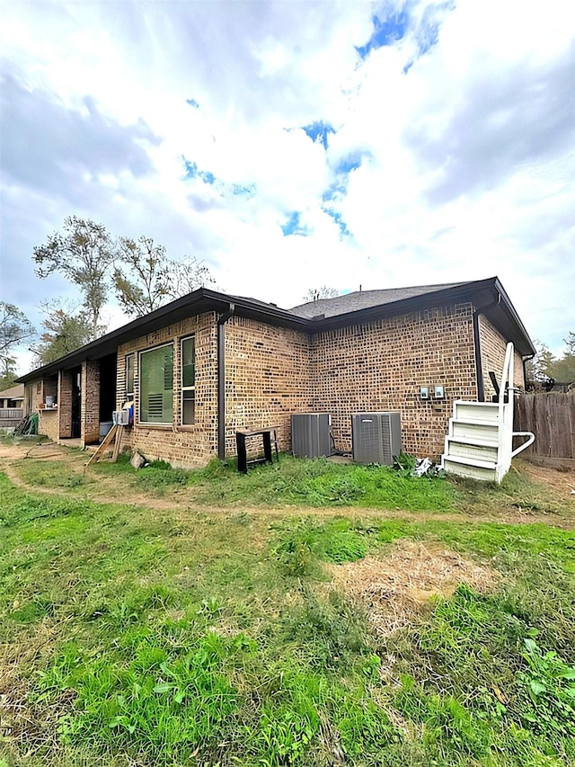 view of home's exterior with a lawn and central AC