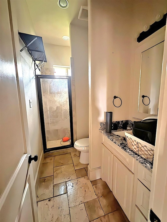 bathroom featuring vanity, toilet, and walk in shower