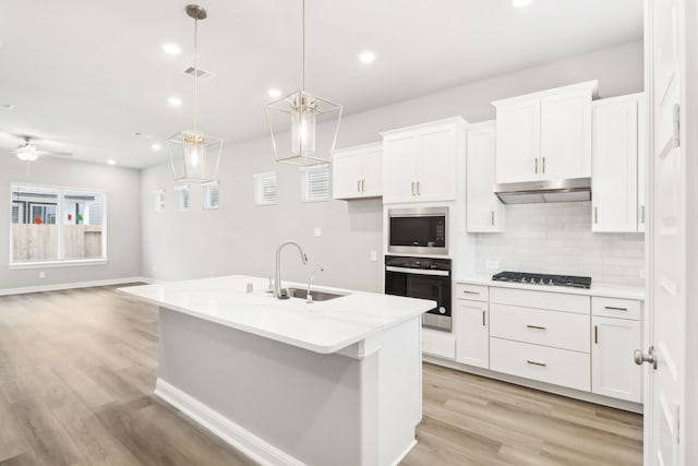 kitchen featuring wall oven, white cabinetry, and built in microwave