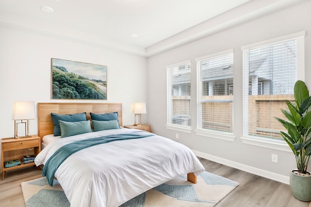 bedroom with hardwood / wood-style floors and multiple windows