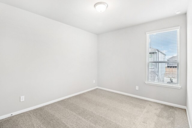 unfurnished room with light colored carpet and a wealth of natural light