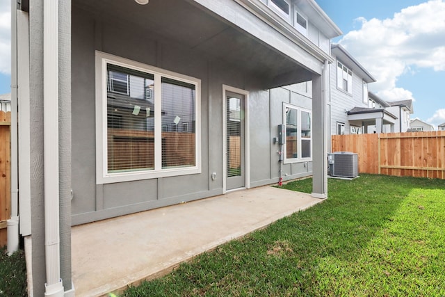 back of house with central AC unit, a patio area, and a yard