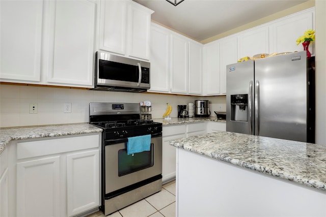 kitchen featuring decorative backsplash, appliances with stainless steel finishes, light stone counters, light tile patterned floors, and white cabinets