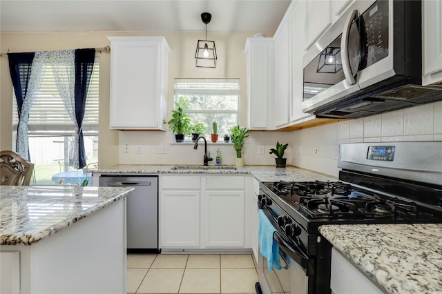 kitchen with white cabinets, appliances with stainless steel finishes, a healthy amount of sunlight, and sink