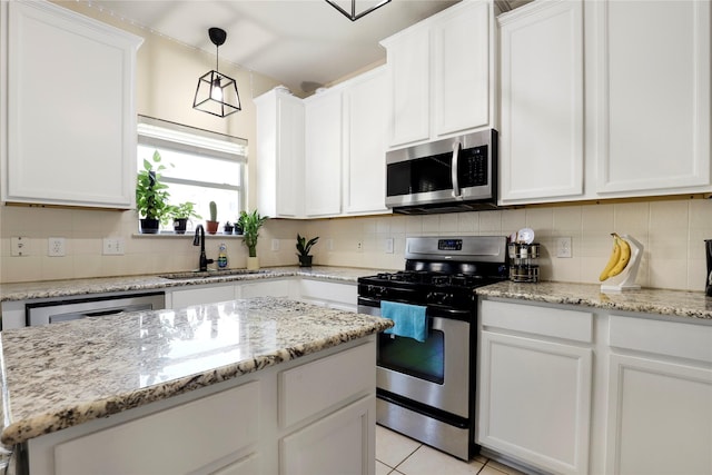 kitchen featuring white cabinets, hanging light fixtures, sink, and appliances with stainless steel finishes