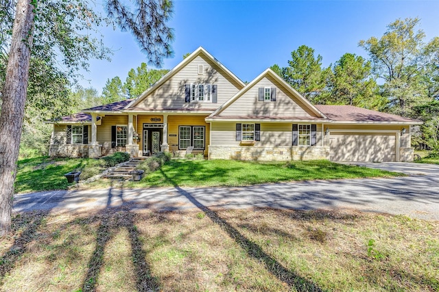 craftsman-style house featuring a front lawn, a porch, and a garage