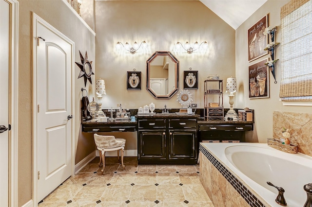 bathroom featuring vanity, lofted ceiling, and tiled tub