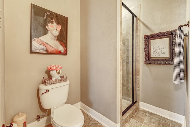 bathroom with a shower with shower door and toilet