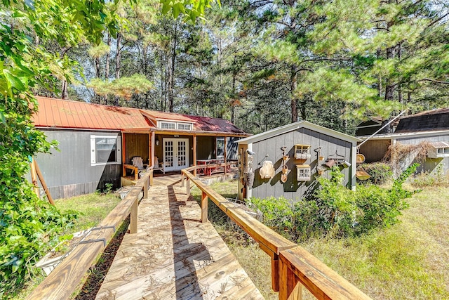 back of house with french doors and an outdoor structure