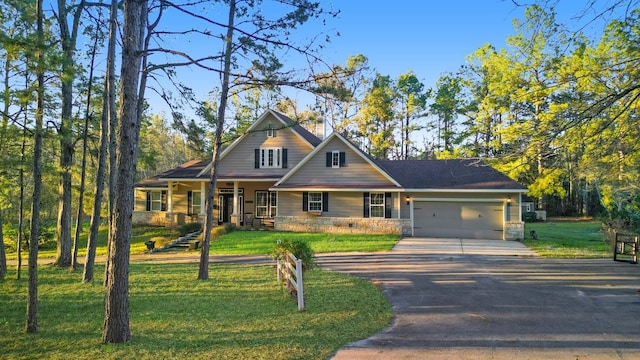 view of front of home featuring a chimney, a porch, an attached garage, a front yard, and driveway