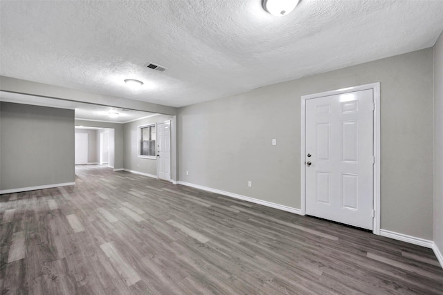 interior space with dark hardwood / wood-style flooring and a textured ceiling