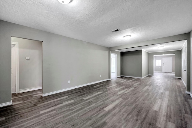 unfurnished room with a textured ceiling and dark hardwood / wood-style floors