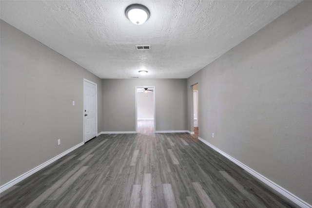 empty room featuring a textured ceiling and dark wood-type flooring