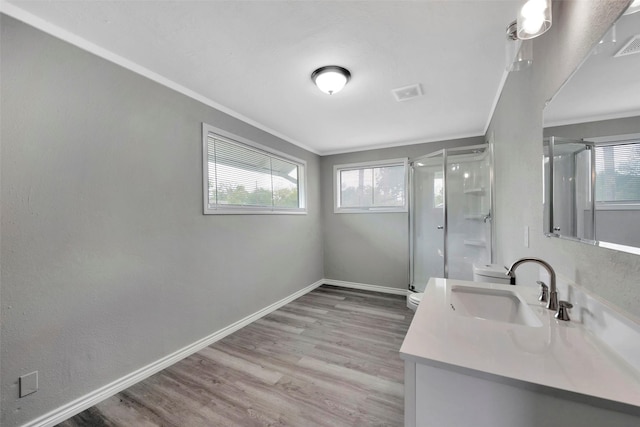 bathroom with vanity, crown molding, hardwood / wood-style flooring, toilet, and a shower with shower door