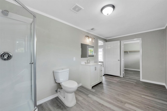 bathroom with hardwood / wood-style floors, vanity, a shower with door, toilet, and ornamental molding