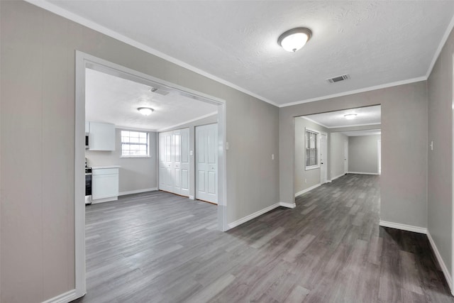 hall featuring a textured ceiling, wood-type flooring, and crown molding