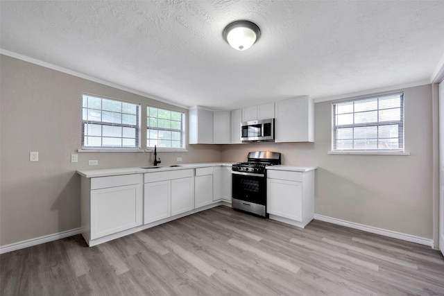 kitchen featuring sink, white cabinets, light wood-type flooring, and appliances with stainless steel finishes