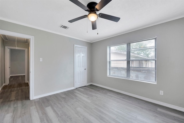 unfurnished bedroom with ceiling fan, a closet, light hardwood / wood-style floors, and ornamental molding