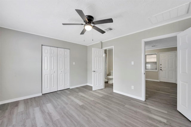 unfurnished bedroom featuring a closet, light hardwood / wood-style floors, ceiling fan, and crown molding